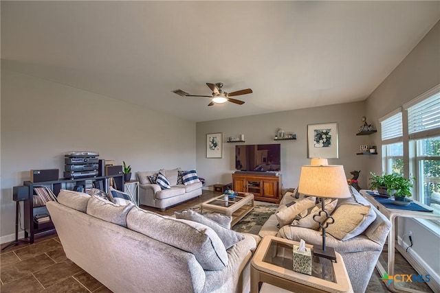 living room featuring baseboards and a ceiling fan