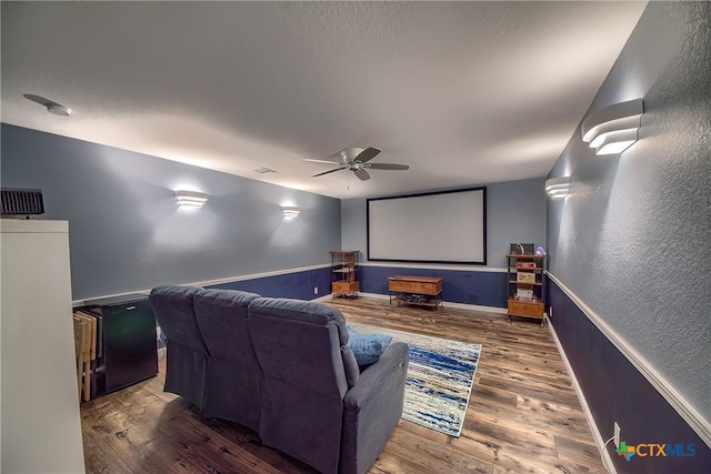 home theater with baseboards, a ceiling fan, and wood finished floors