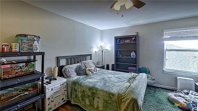bedroom featuring dark wood finished floors, ceiling fan, and baseboards