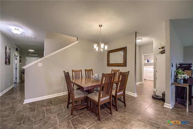 dining room featuring a chandelier, visible vents, and baseboards