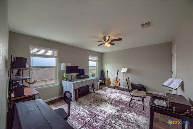 home office with ceiling fan, baseboards, wood finished floors, and visible vents
