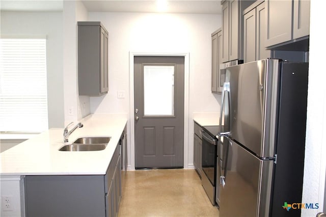 kitchen with sink, gray cabinets, kitchen peninsula, and appliances with stainless steel finishes