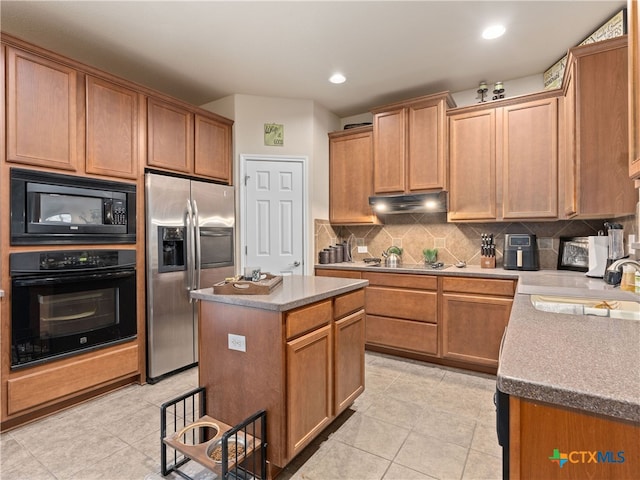 9823 Amberg Path, Helotes, TX 78023 - kitchen with black appliances, backsplash, light tile patterned flooring, under cabinet range hood, and a kitchen island