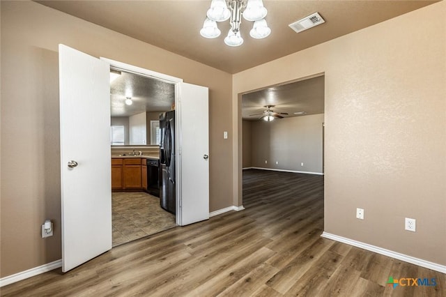 interior space featuring hardwood / wood-style floors, ceiling fan with notable chandelier, and sink