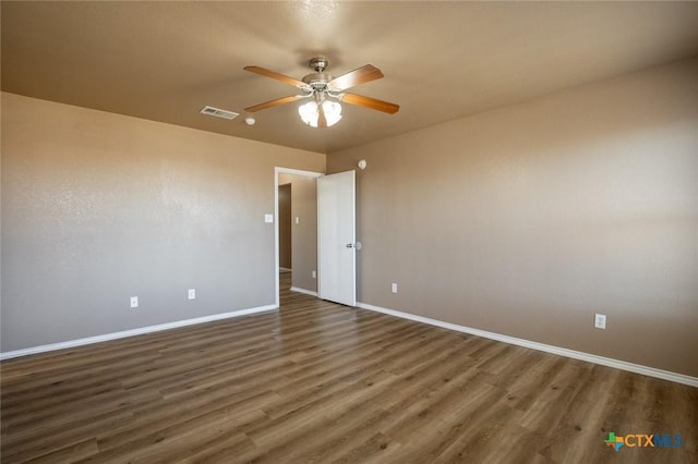 spare room with ceiling fan and dark wood-type flooring