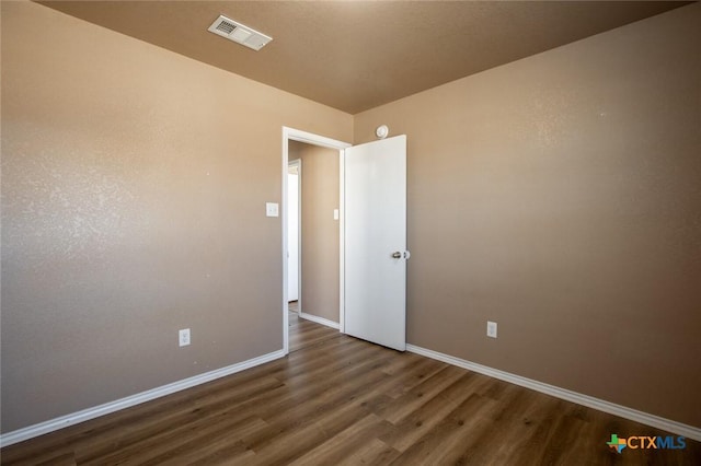 spare room featuring dark wood-type flooring