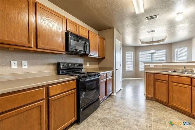 kitchen featuring a textured ceiling, sink, hanging light fixtures, and black appliances