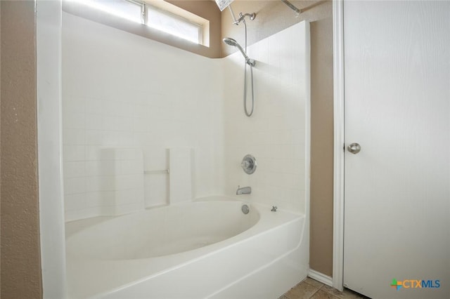 bathroom with tile patterned floors and washtub / shower combination