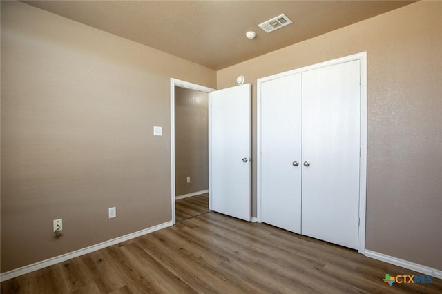 unfurnished bedroom featuring wood-type flooring and a closet