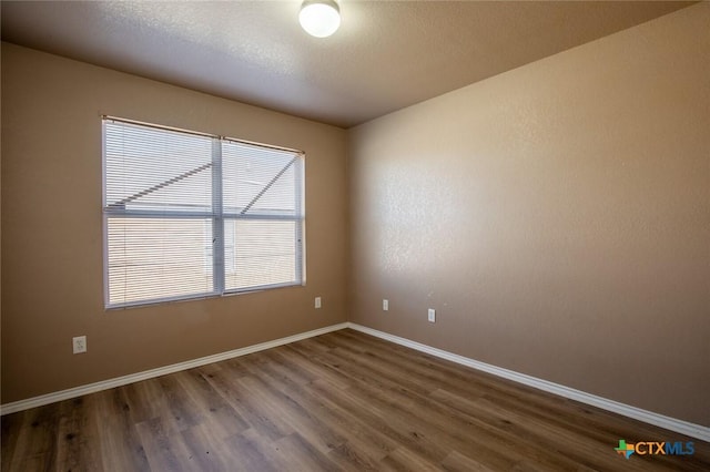 spare room with dark hardwood / wood-style flooring