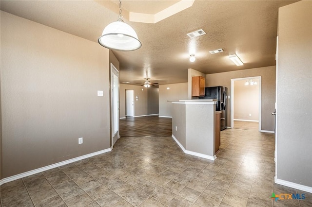 kitchen with a textured ceiling, ceiling fan, wood-type flooring, and decorative light fixtures