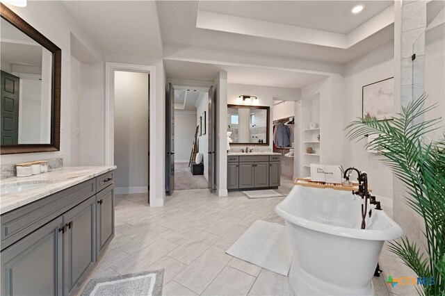 bathroom featuring vanity, plus walk in shower, and a wealth of natural light