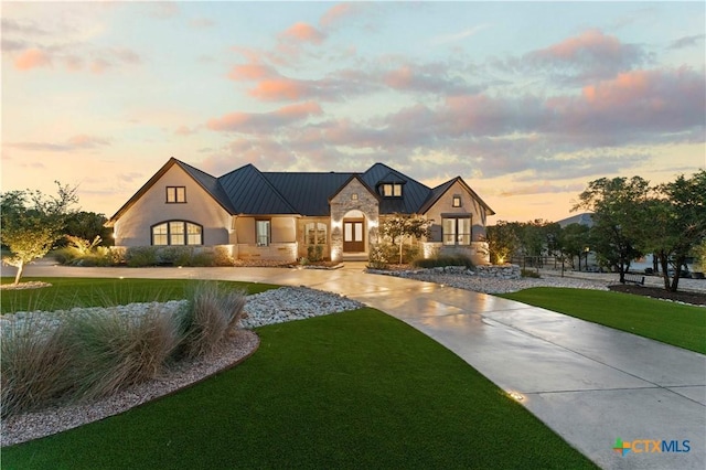 632 Carson Rdg, New Braunfels, TX 78132 - view of front of house featuring a standing seam roof, a lawn, stucco siding, and metal roof