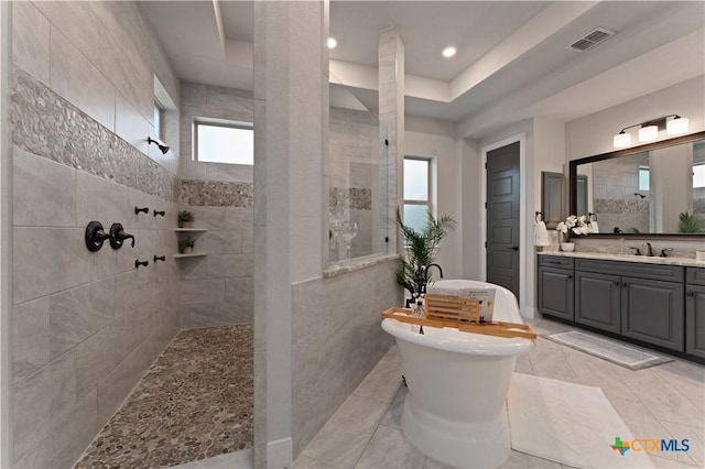 632 Carson Rdg, New Braunfels, TX 78132 - bathroom with a walk in shower, vanity, tile patterned floors, recessed lighting, and tile walls