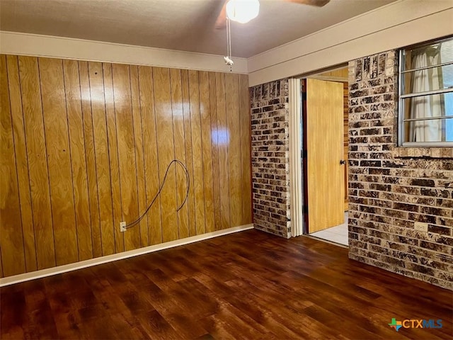 6414 Fm 234 N, Edna, TX 77957 - unfurnished room featuring wooden walls, wood finished floors, ceiling fan, and brick wall