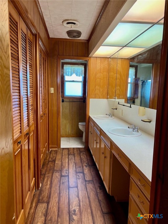 6414 Fm 234 N, Edna, TX 77957 - full bathroom with wood-type flooring, toilet, wooden walls, and double vanity
