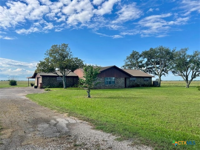 6414 Fm 234 N, Edna, TX 77957 - view of side of home with dirt driveway, a yard, board and batten siding, and stone siding