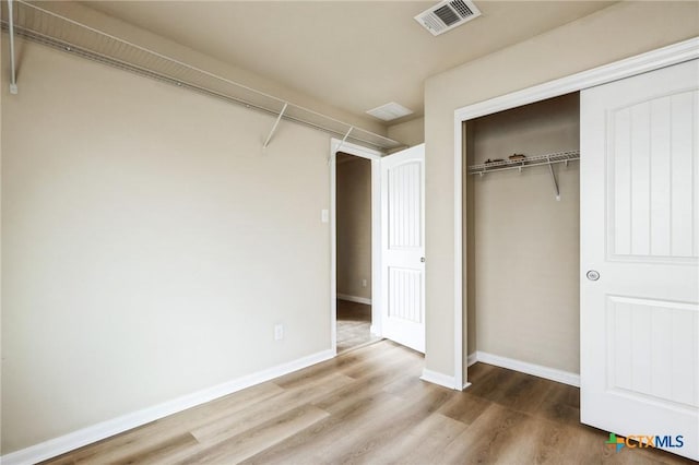 unfurnished bedroom featuring hardwood / wood-style floors and a closet