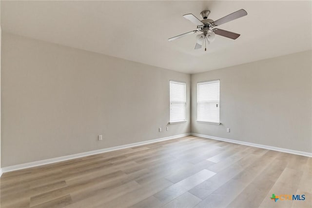 empty room with ceiling fan and light hardwood / wood-style flooring