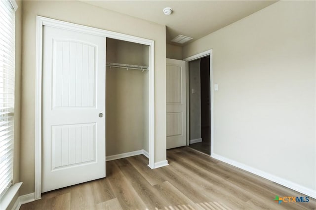 unfurnished bedroom featuring light hardwood / wood-style floors and a closet