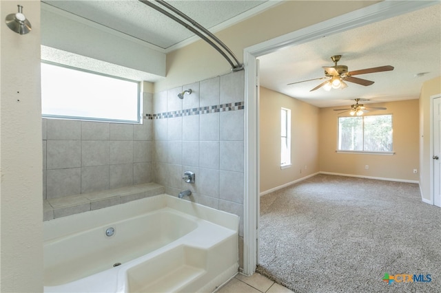 bathroom with tiled shower / bath, a textured ceiling, tile patterned floors, and a healthy amount of sunlight