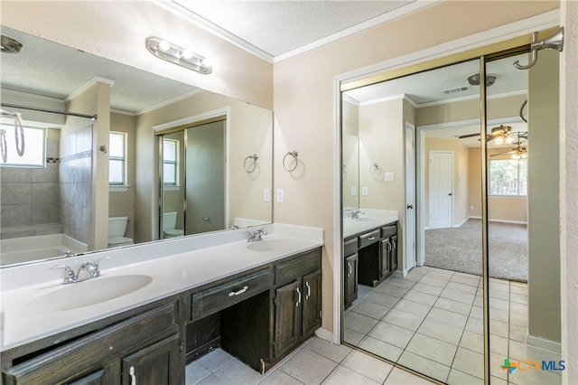 bathroom featuring a textured ceiling, vanity, crown molding, tile patterned floors, and toilet