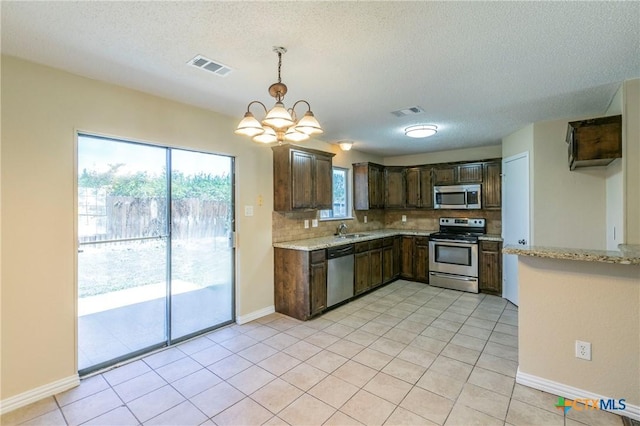 802 Antelope Trl, Temple, TX 76504 - kitchen with appliances with stainless steel finishes, backsplash, a chandelier, dark brown cabinetry, and a textured ceiling