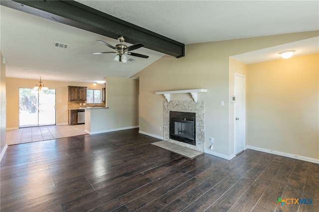 unfurnished living room with ceiling fan with notable chandelier, a textured ceiling, dark hardwood / wood-style flooring, a high end fireplace, and lofted ceiling with beams