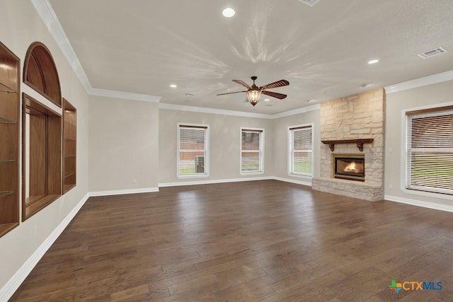 unfurnished living room featuring a stone fireplace, dark wood-type flooring, and ornamental molding