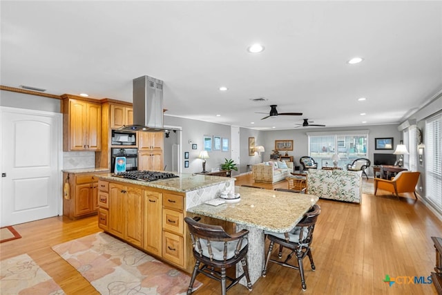 kitchen with black appliances, a kitchen island, island exhaust hood, and light wood-type flooring