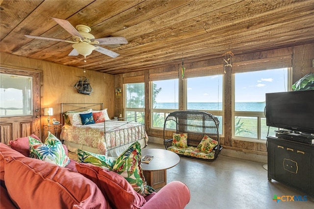 bedroom featuring ceiling fan, wooden walls, wood ceiling, and concrete floors