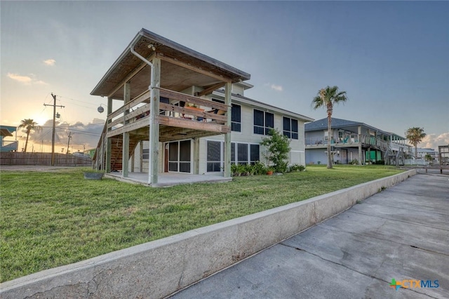 100 Bayshore Drive, Ingleside On The Bay, TX 78362 - back of property at dusk featuring a lawn, a balcony, and a patio