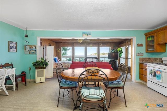 dining space featuring a textured ceiling and crown molding