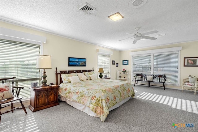 carpeted bedroom with a textured ceiling and ceiling fan