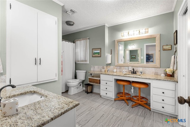 bathroom with ornamental molding, vanity, a textured ceiling, and toilet