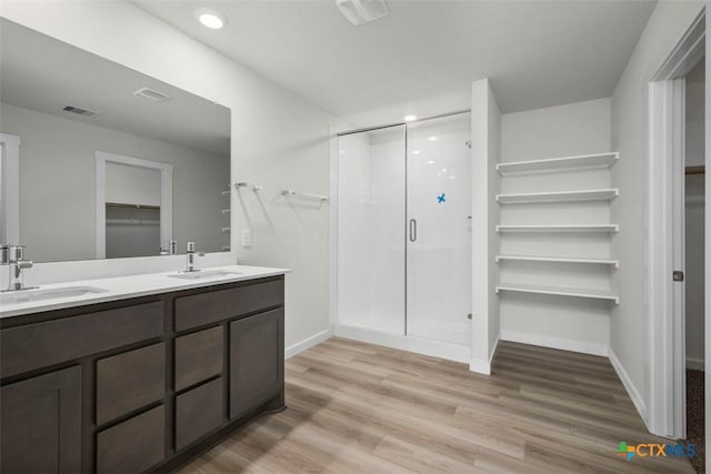 2508 Torbensen Ct, Temple, TX 76504 - bathroom featuring a spacious closet, a shower stall, wood finished floors, double vanity, and baseboards