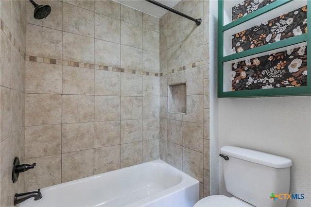 bathroom with toilet and tiled shower / bath