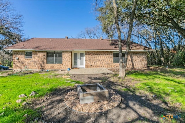 back of property with a patio area and a yard