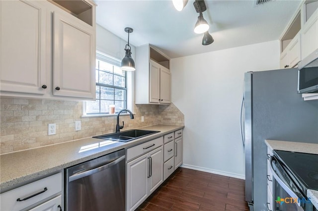 kitchen with pendant lighting, white cabinets, sink, decorative backsplash, and appliances with stainless steel finishes