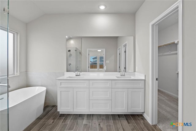 bathroom featuring vanity, lofted ceiling, and independent shower and bath