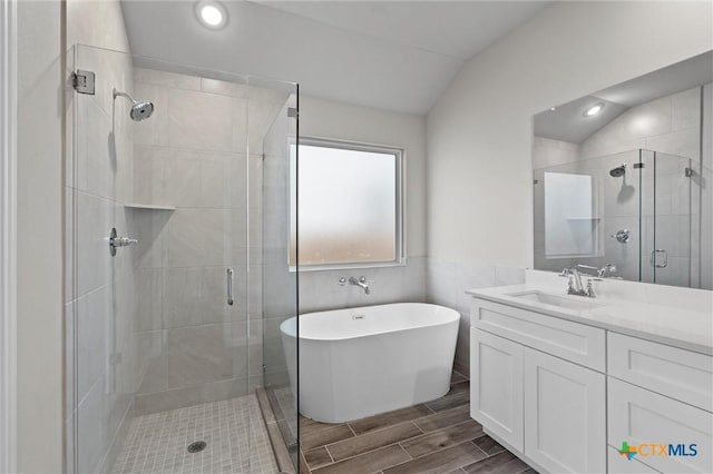 bathroom with vaulted ceiling, separate shower and tub, and vanity