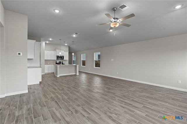 unfurnished living room featuring ceiling fan and light hardwood / wood-style flooring