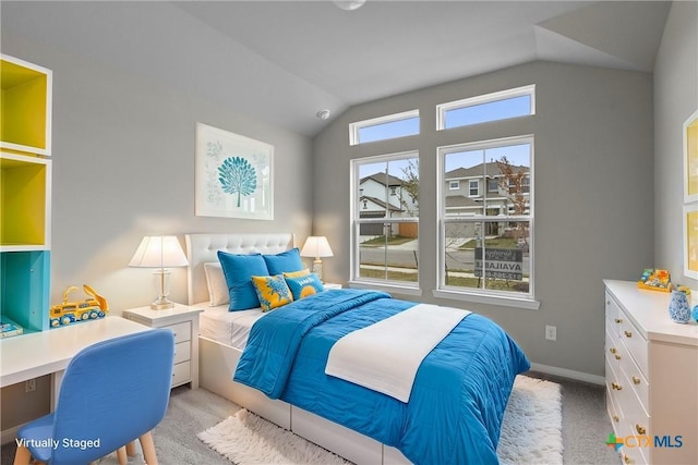 bedroom featuring multiple windows, vaulted ceiling, and light carpet