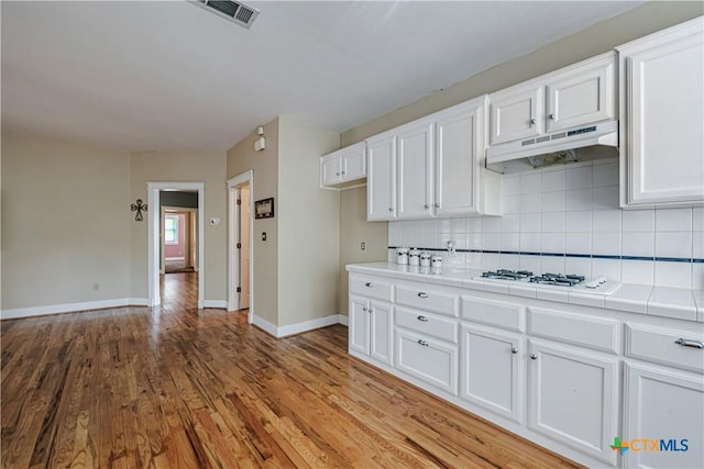 2006 Rose Cir, Harker Heights, TX 76548 - kitchen with tile countertops, under cabinet range hood, white gas stovetop, and white cabinetry