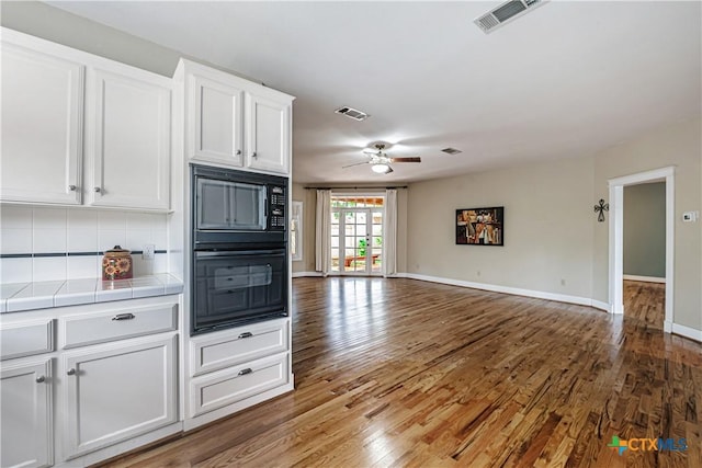 2006 Rose Cir, Harker Heights, TX 76548 - kitchen featuring tile countertops, black appliances, open floor plan, white cabinets, and wood finished floors