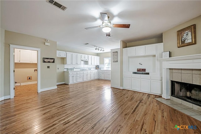2006 Rose Cir, Harker Heights, TX 76548 - unfurnished living room featuring a ceiling fan, light wood finished floors, and a fireplace