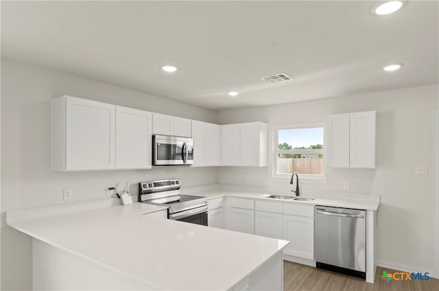 1007 Antelope Trl, Temple, TX 76504 - kitchen featuring stainless steel appliances, a peninsula, recessed lighting, white cabinets, and light countertops