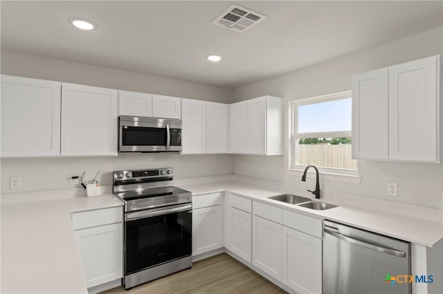 1007 Antelope Trl, Temple, TX 76504 - kitchen with stainless steel appliances, white cabinetry, light countertops, and recessed lighting