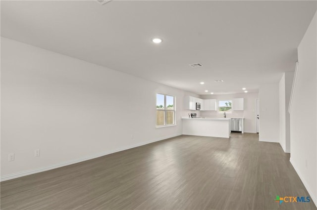 1007 Antelope Trl, Temple, TX 76504 - unfurnished living room with recessed lighting and dark wood-style flooring