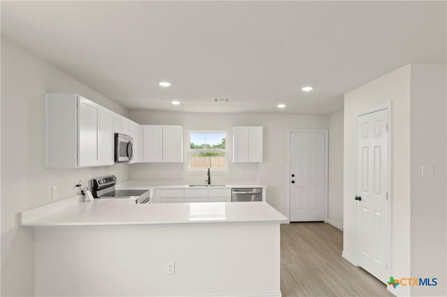 1007 Antelope Trl, Temple, TX 76504 - kitchen with stainless steel appliances, recessed lighting, light countertops, a peninsula, and light wood-style flooring